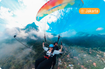 Paraglider flying over the scenic mountain landscape of Bogor