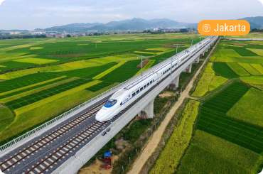 High-speed train traveling through green rice fields on a one-day trip to Bandung