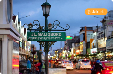 Malioboro Street in Yogyakarta with city lights, shops, and evening traffic
